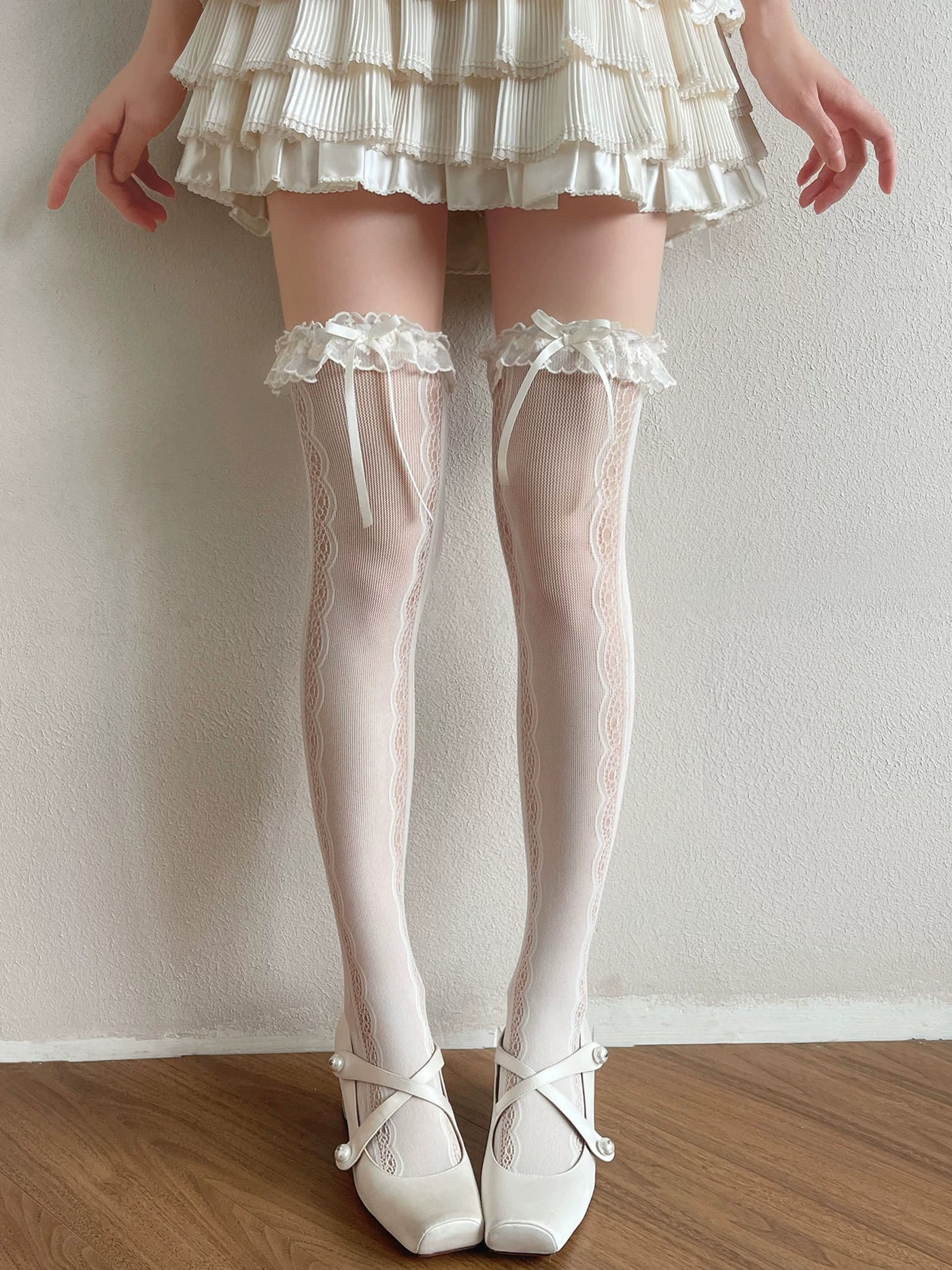 White and black lace-panel over-the-knee socks with ruffled cuffs and ribbon bows.