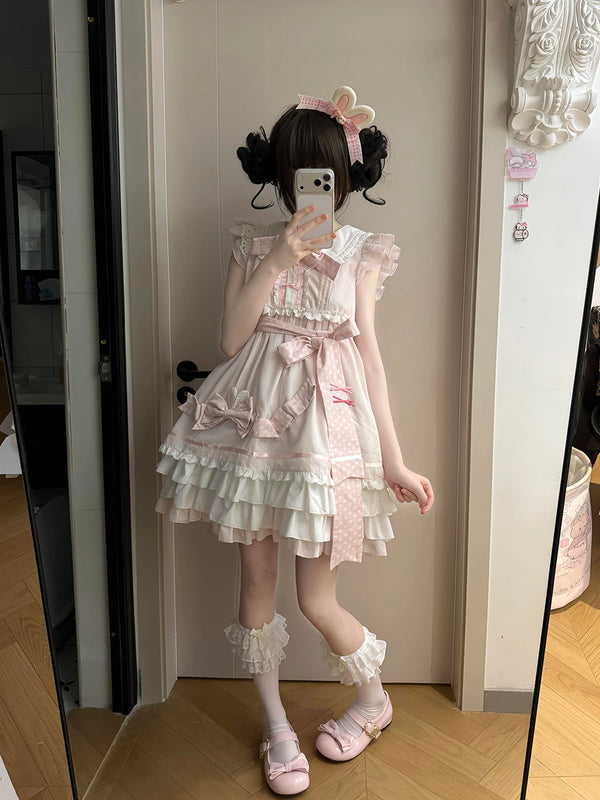 Model wearing a pink-and-white bow-trimmed one-piece dress with a tiered ruffle skirt.
