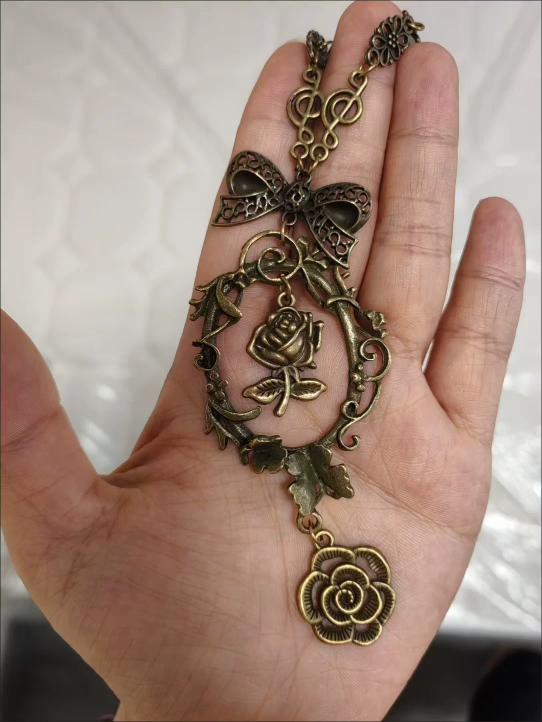 Little Fortune rose-toned floral pendant necklace with butterfly and bow charms
