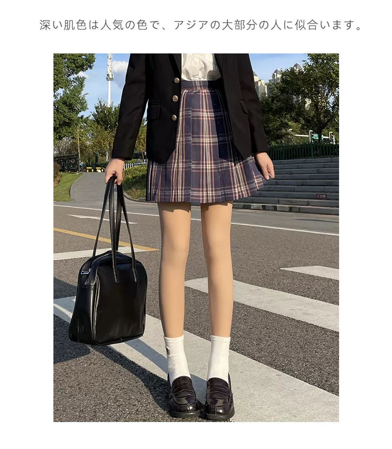 Skin-tone tights worn with a plaid skirt, black blazer and loafers in outdoor styling.