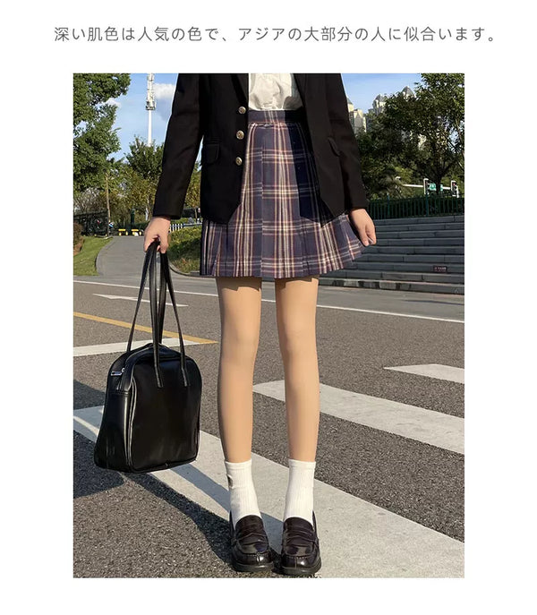 Skin-tone tights worn with a plaid skirt, black blazer and loafers in outdoor styling.