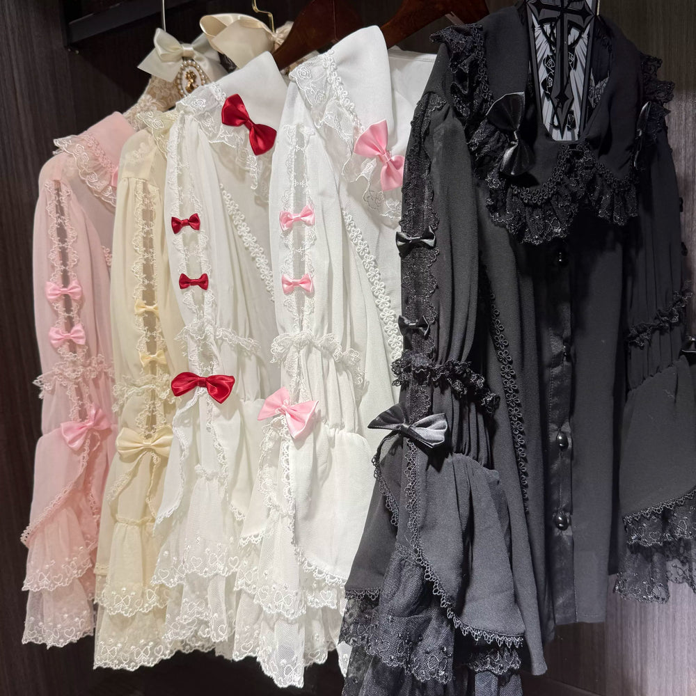 White lace-trimmed hime-sleeve blouse with ruffled tiers and sleeve bows styled over a black skirt.