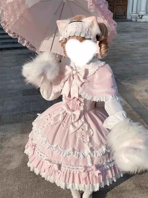 Model wearing a pink layered JSK with white ruffles and a cape.