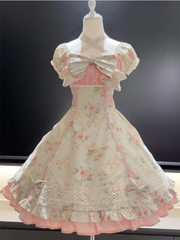 Pink floral OP dress on a mannequin with puff sleeves, bow front, lace trim, and layered hem.