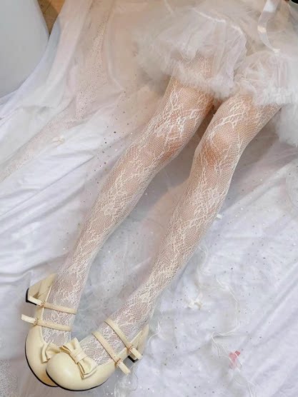 Pale yellow floral lace tights styled with cream bow shoes