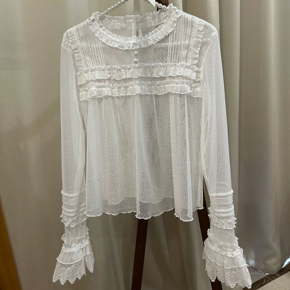 White sheer ruffle-trimmed long-sleeve inner top hanging on a pearl hanger.