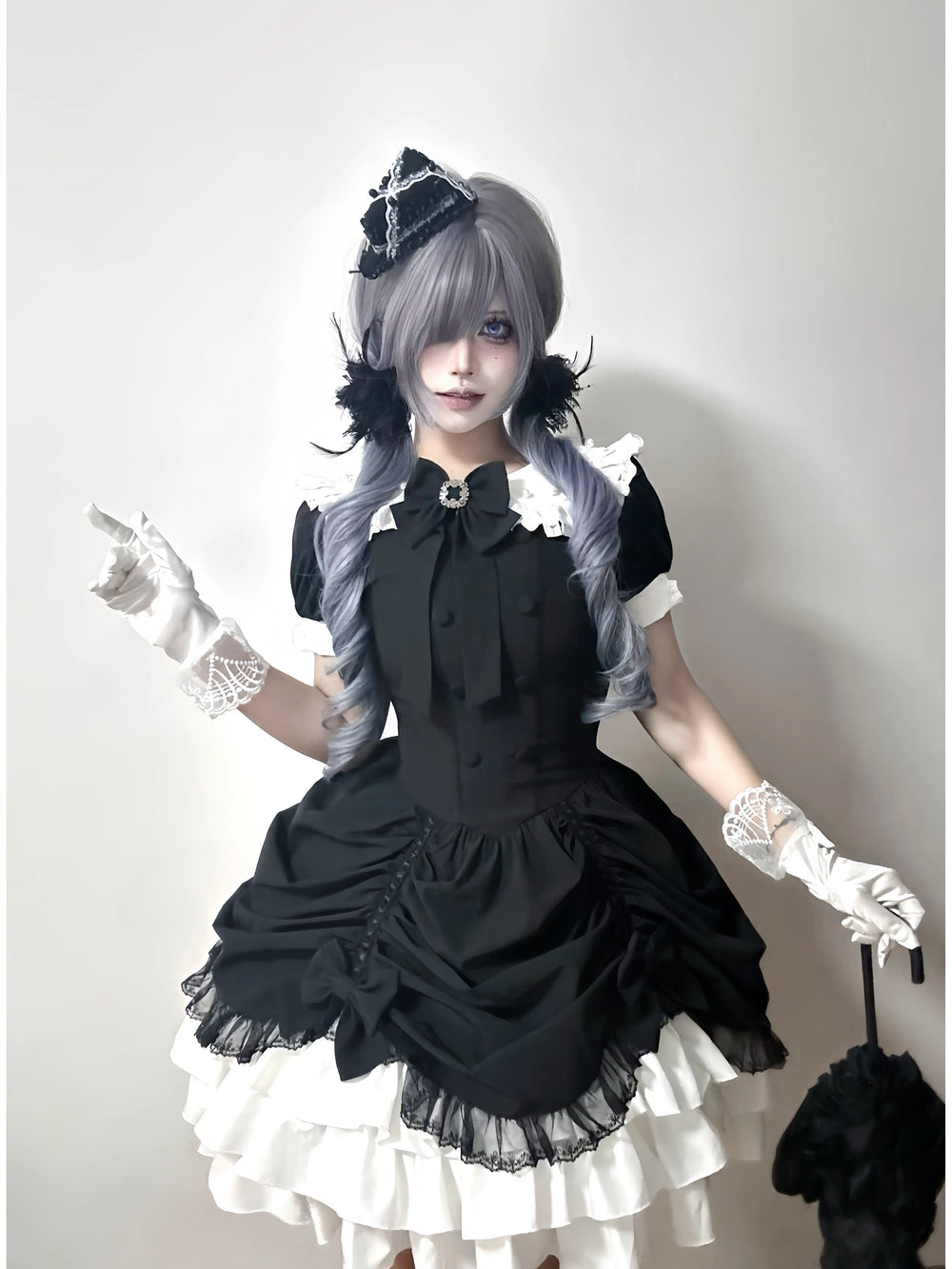 Creamy black-and-white Gothic Lolita dress with a large bow and layered white ruffles.