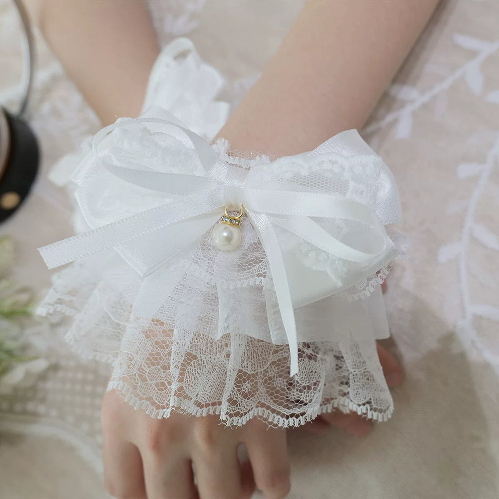 White lace wrist cuffs with ribbon bows and pearl accents