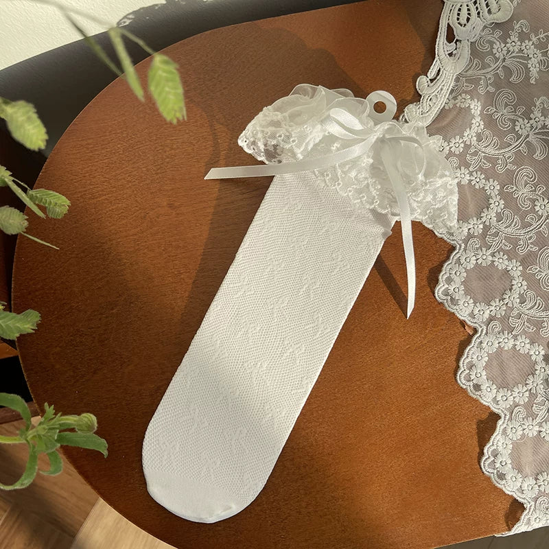 Sock Noble white lace mid-calf socks with ruffled cuffs and ribbon ties styled with metallic Mary Jane shoes