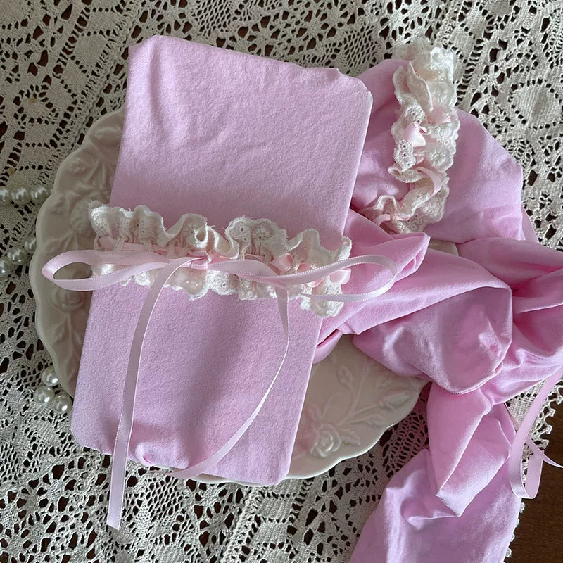 Cream-toned velvet tights with lace-trimmed bands and ribbon bows styled beneath a ruffled skirt.