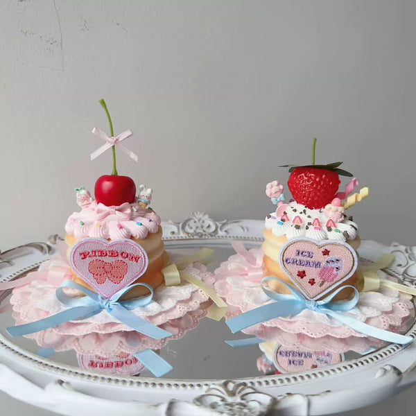 Pastel cake-shaped small top hats with cherry and strawberry toppings, bows and ribbons.