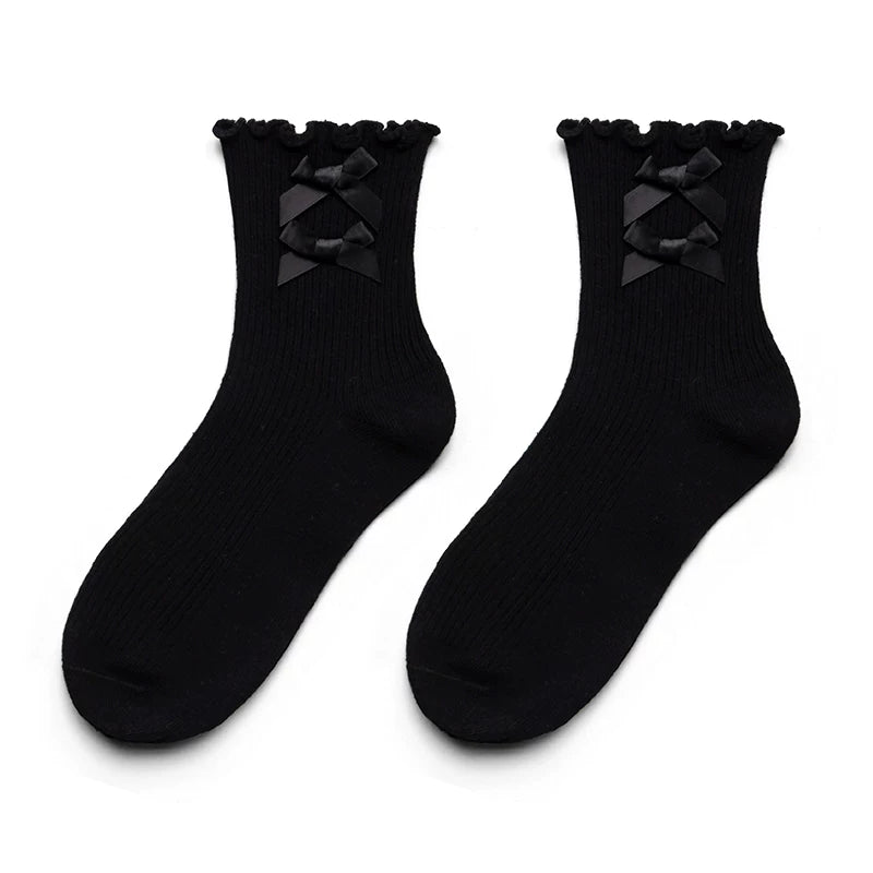 White cotton short socks with bow and ruffle details shown with white shoes.