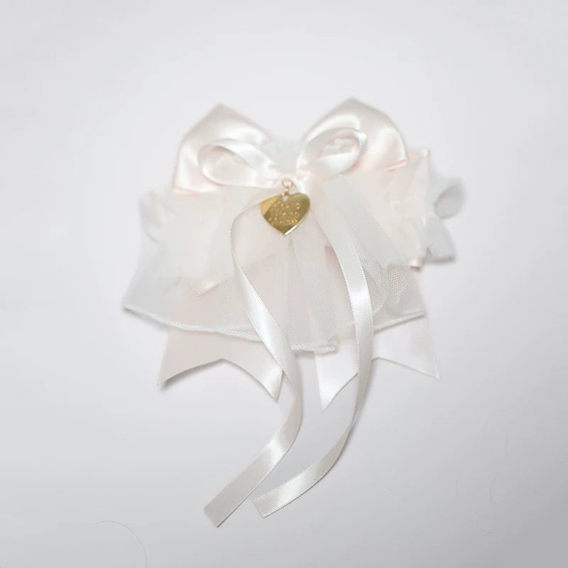 Blue and pink bow hair accessory with layered ruffles and bell on a mannequin