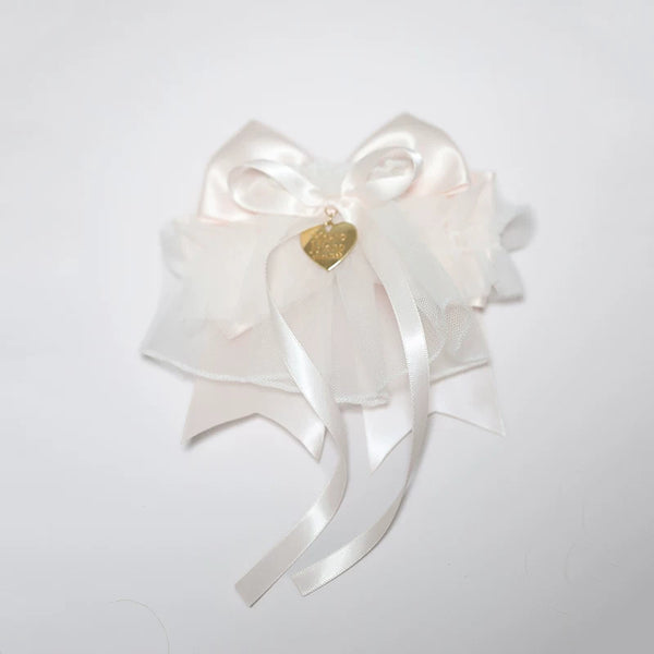 Blue and pink bow hair accessory with layered ruffles and bell on a mannequin