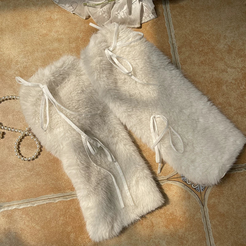 Long white plush leg warmers with tie details styled over pale tights