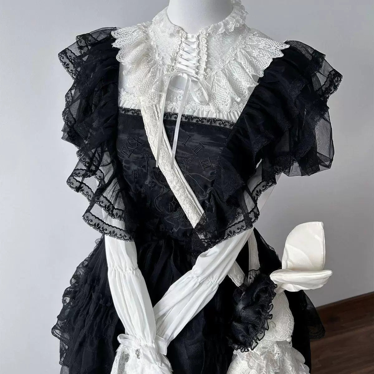 White lace crossover-collar blouse displayed on a dress form
