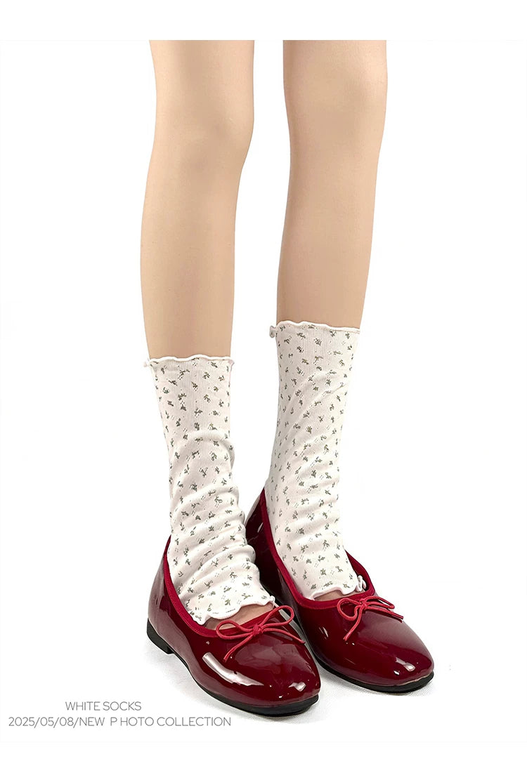 White floral scrunch mid-calf socks with rolled edges styled with burgundy ballet flats