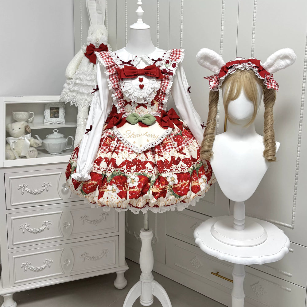 Red strawberry-print JSK with layered ruffles, bows and a matching short-sleeved blouse laid flat.