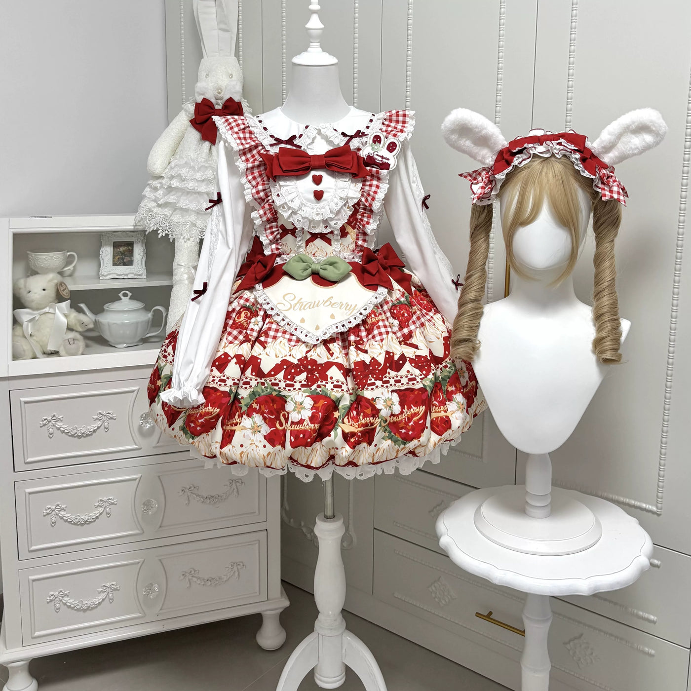 Red strawberry-print JSK with layered ruffles, bows and a matching short-sleeved blouse laid flat.
