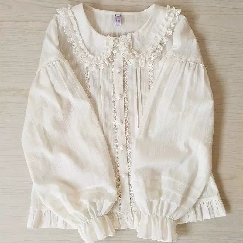 White long-sleeve blouse with lace-trimmed Peter Pan collar, pintucked front and ruffled cuffs.