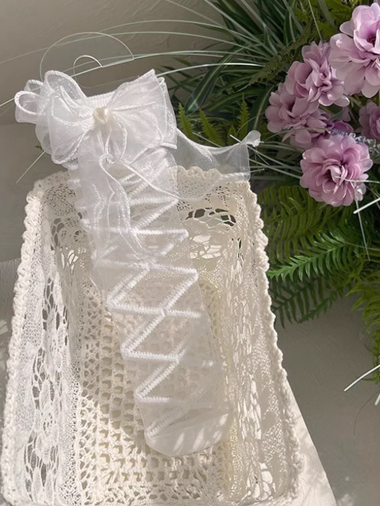 White mid-calf Lolita socks with crossed sheer straps and large bow details