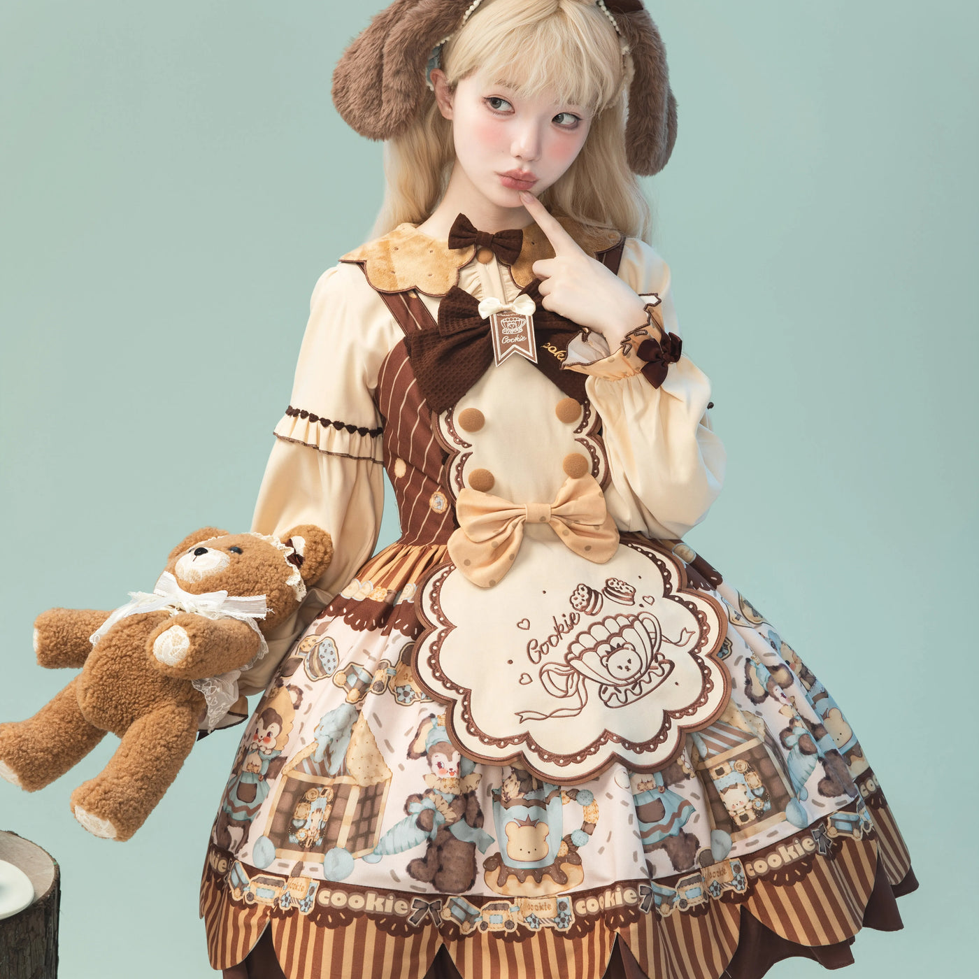 Beige-and-brown bear-cookie printed dress with a large bib panel and teddy-ear headpiece.