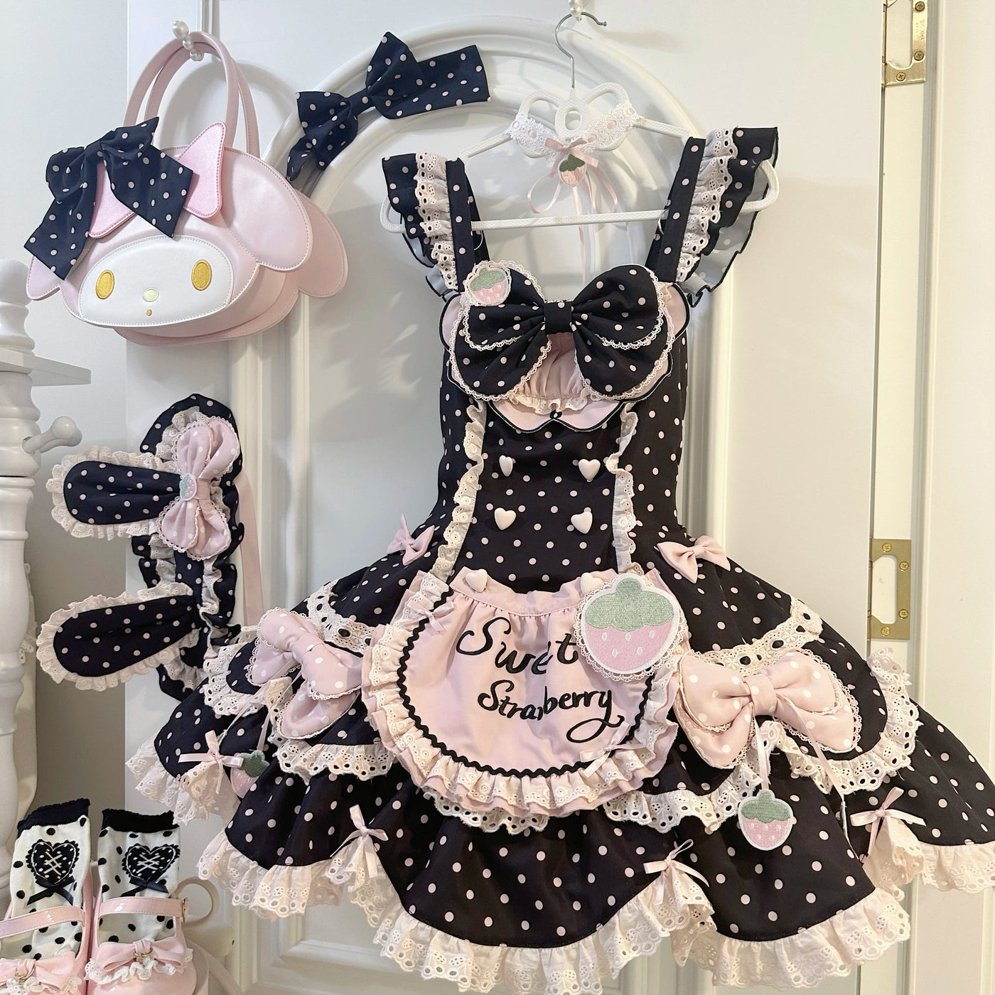Black-pink strawberry polka-dot JSK with layered lace and bow details on a hanger