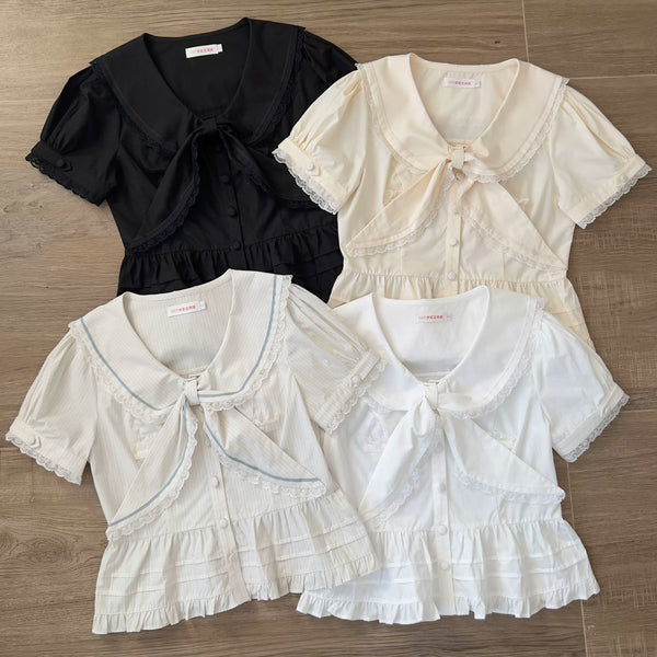 Ivory short-sleeve blouse with a lace-trimmed sailor collar and tie.