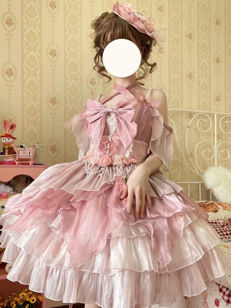 Model wearing a pink ruffled JSK with an oversized bow and rose details.