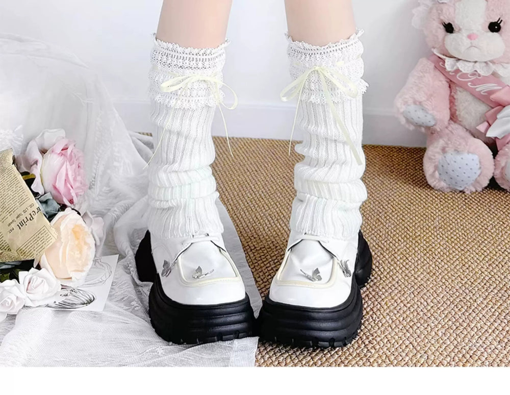 White and black knit socks with lace cuffs and ribbon ties.