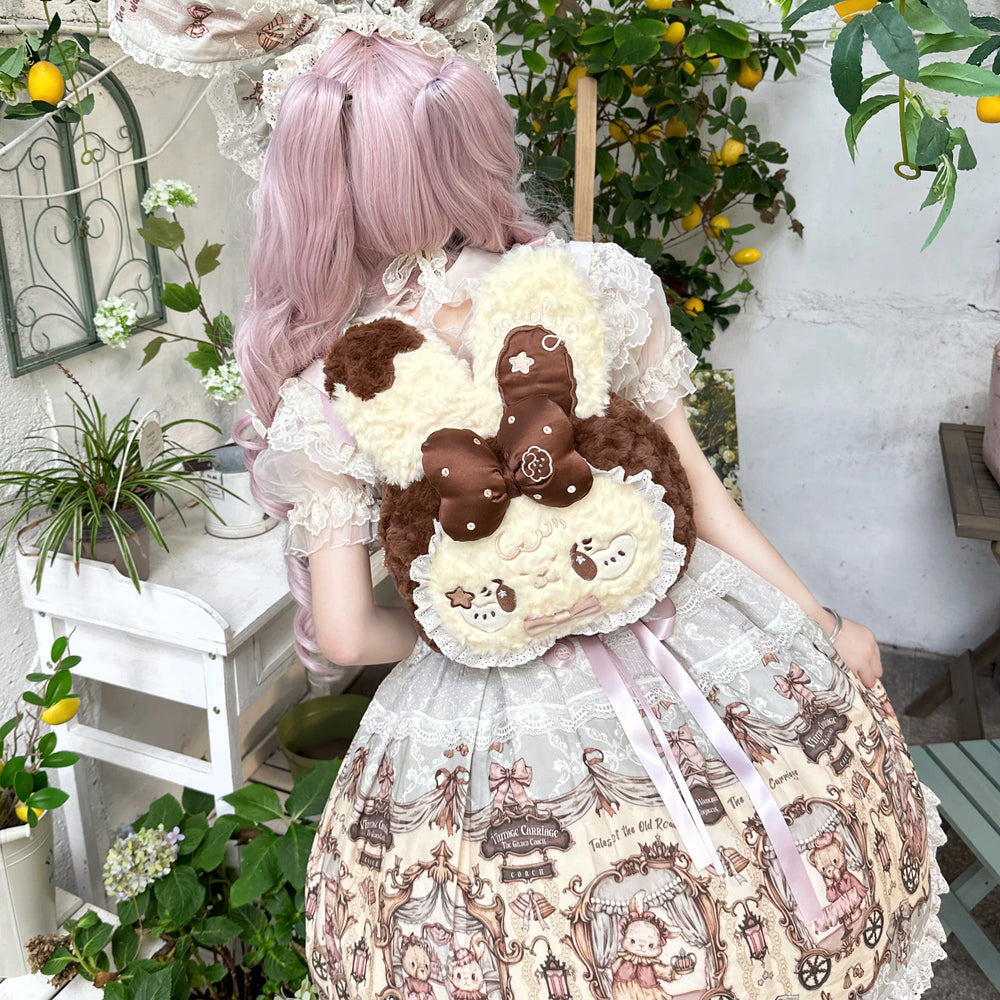Yellow-brown plush rabbit backpack shown front and back on a model.