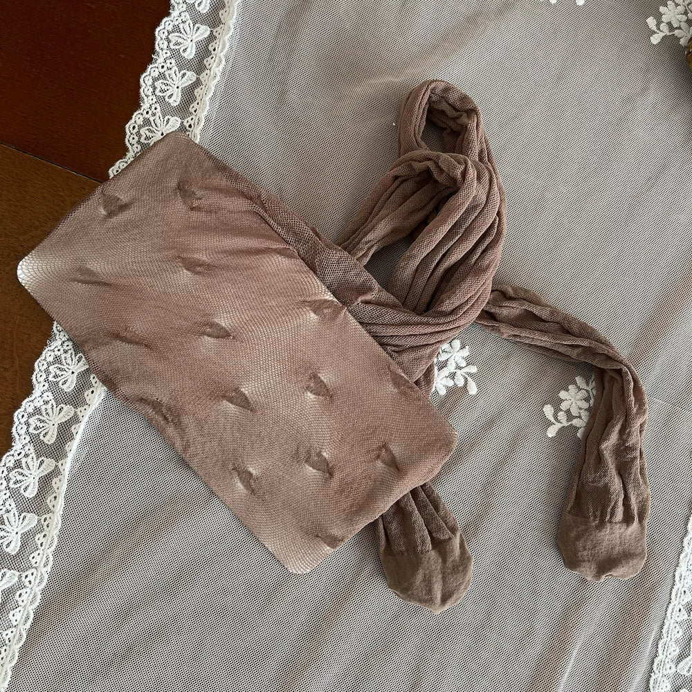 Khaki heart-pattern pantyhose with lace panels and ruffled trims styled with cream shoes.