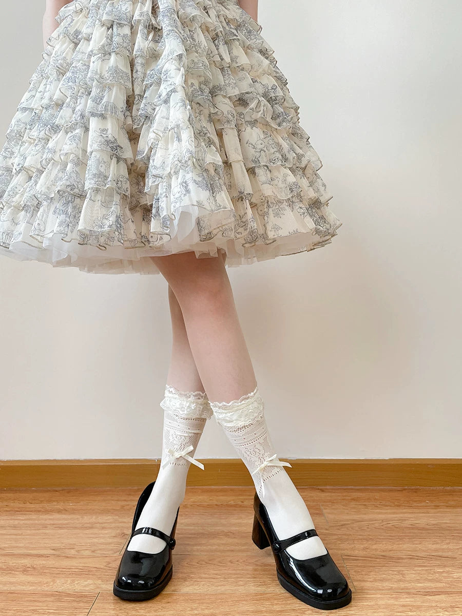 White mid-calf lace socks with ruffled edges and ribbon bows, worn with black strap shoes.