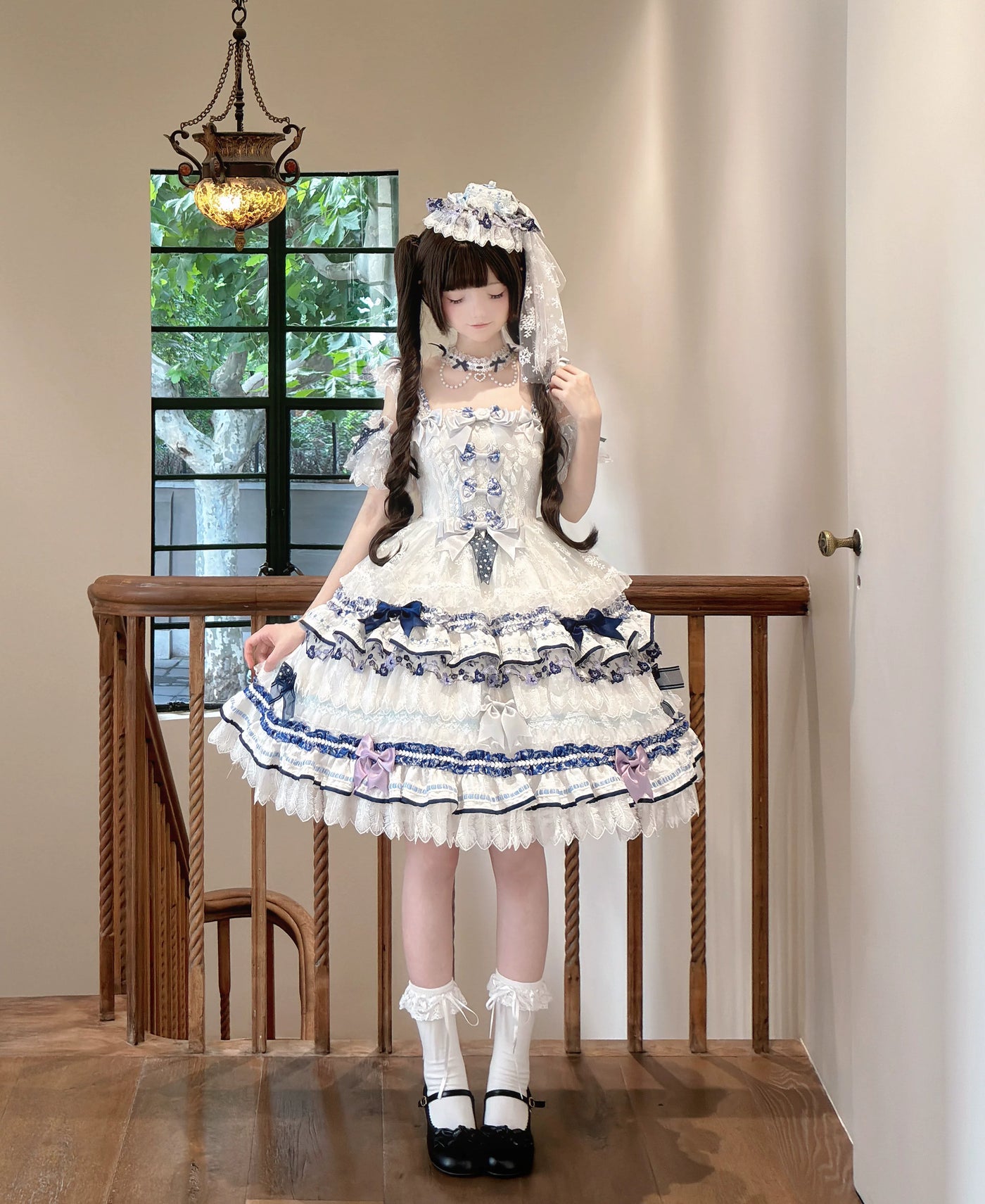 Blue-and-white OP dress with layered lace, bows and floral trim, styled with blue flowers.