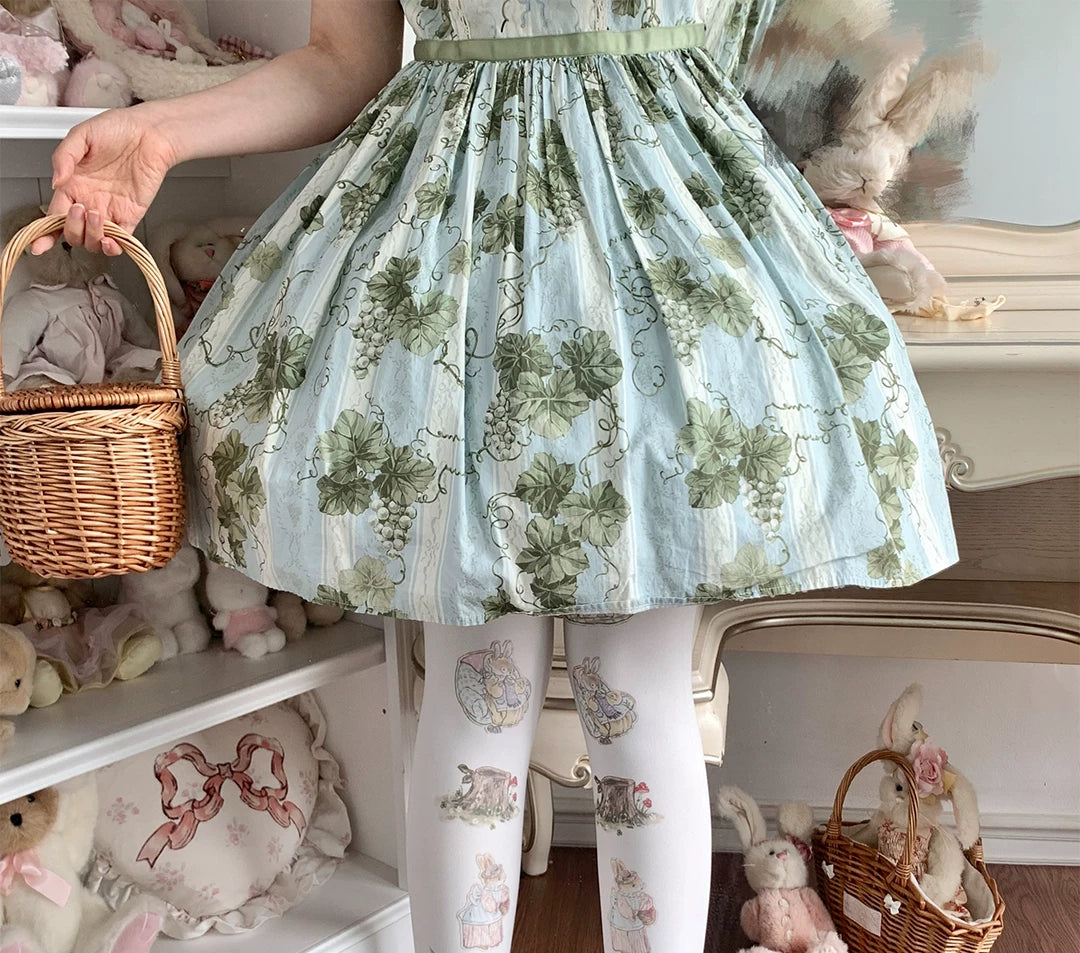 White printed pantyhose with rabbit and woodland illustrations worn beneath a pale blue dress
