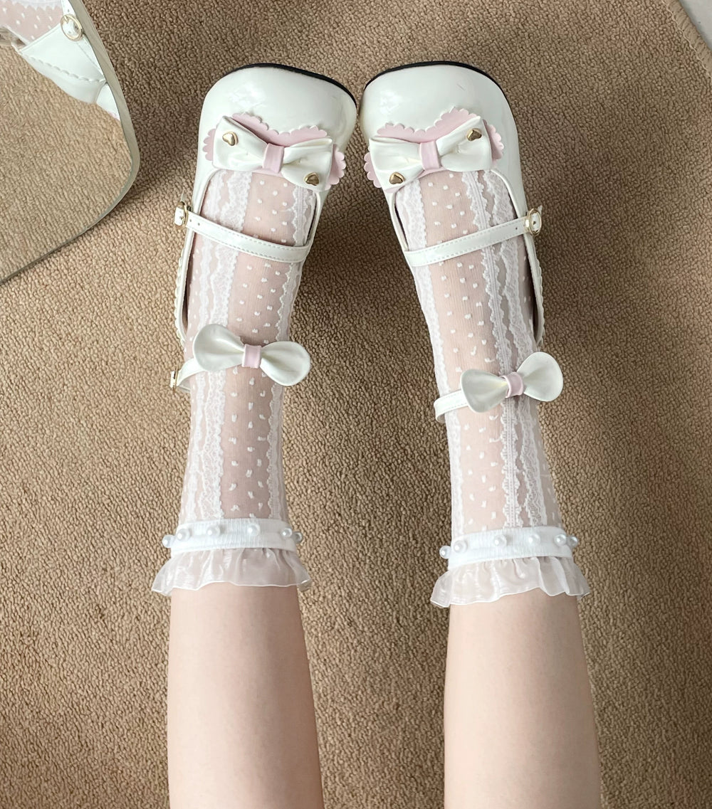 White dotted mesh socks with lace panels, pearl trim, and bows worn with white Mary Jane shoes.