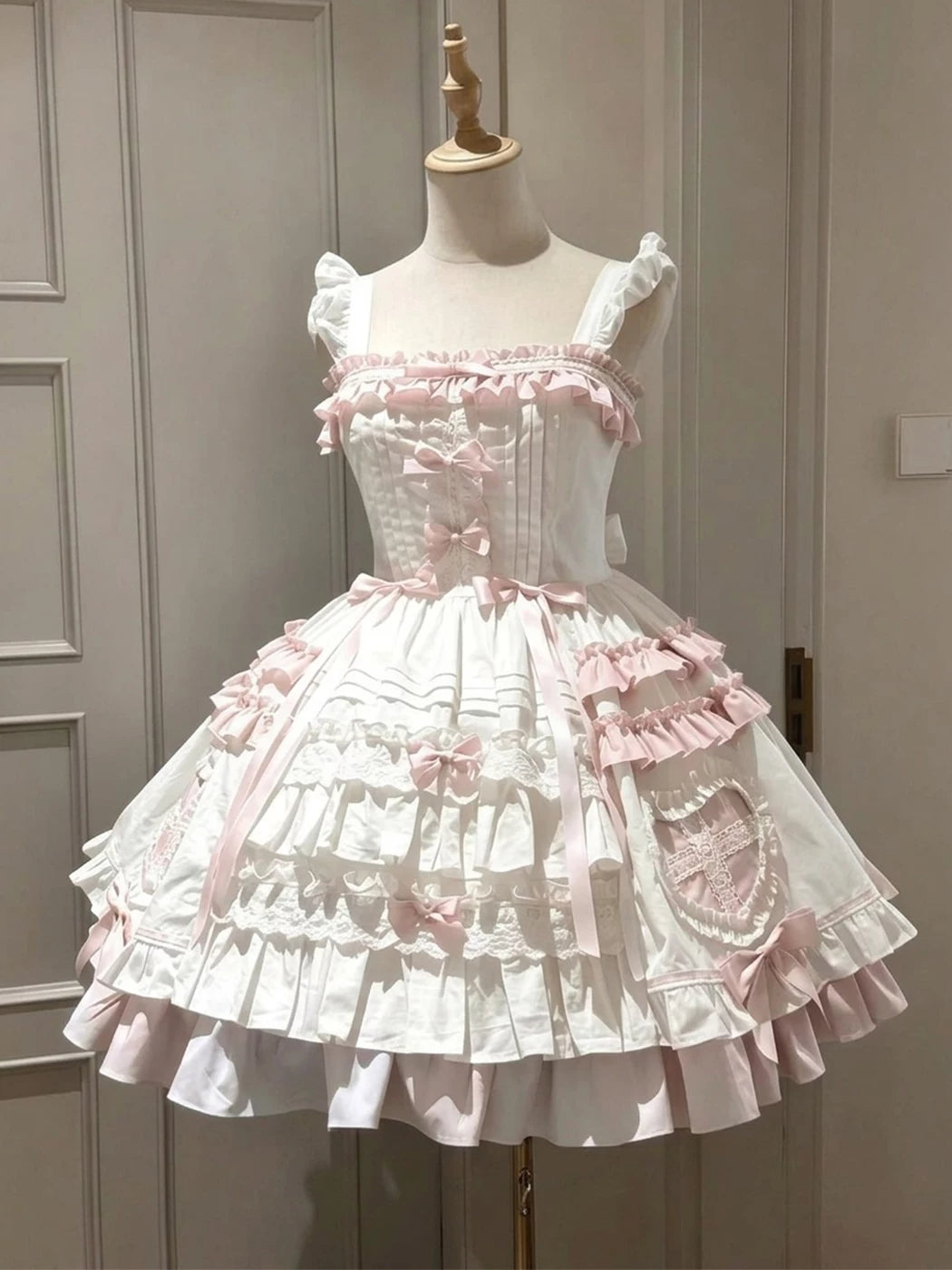 Pink-and-white JSK dress with layered ruffles and a matching cape displayed on a mannequin.