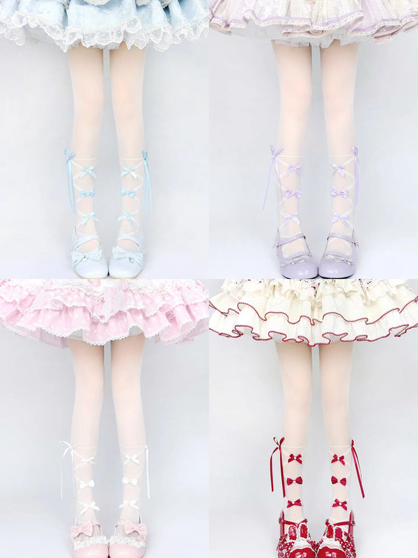Pink bow-detail tights with crisscross ribbon straps styled beneath a ruffled skirt.