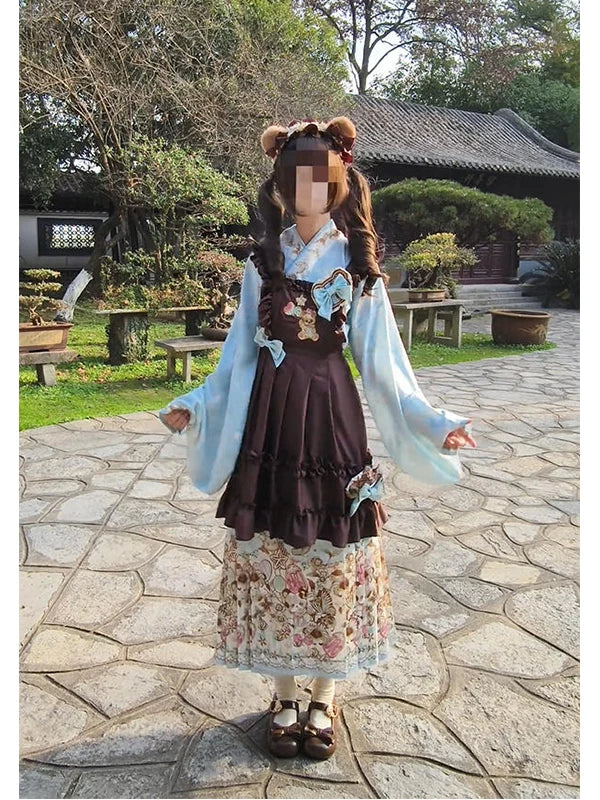 Styled view of a blue top, coffee-colored embroidered overskirt and floral mamian skirt.