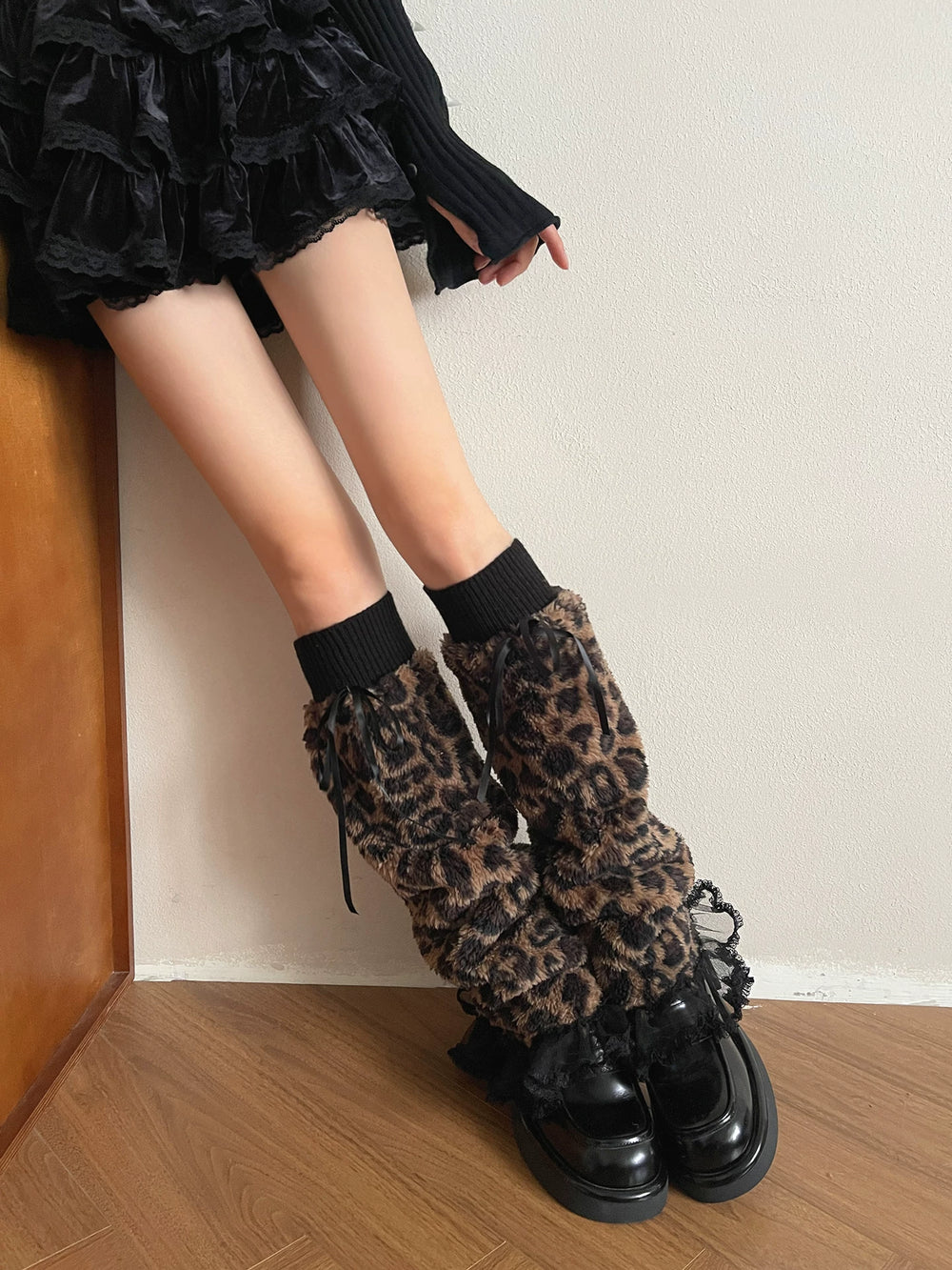 Leopard-print long sock covers with black ribbed cuffs, ribbon ties and lace edging styled with platform shoes.