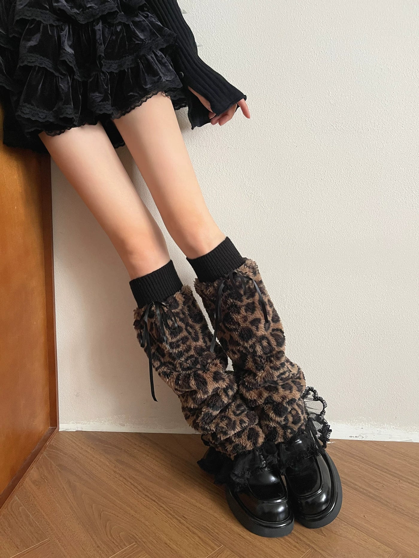 Leopard-print long sock covers with black ribbed cuffs, ribbon ties and lace edging styled with platform shoes.