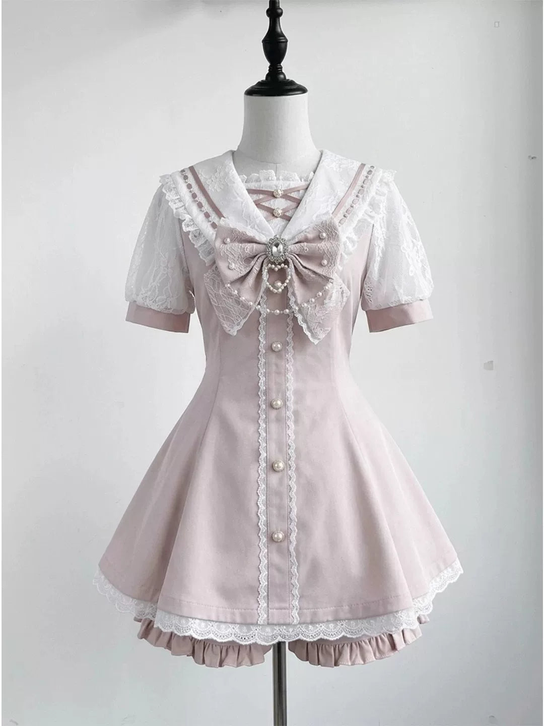 Pink lace sailor-collar top and shorts set displayed on a dress form.