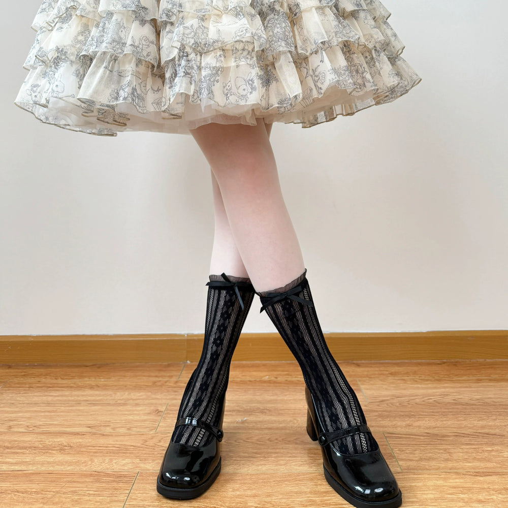White and black openwork lace mid-calf socks with scalloped bow cuffs.