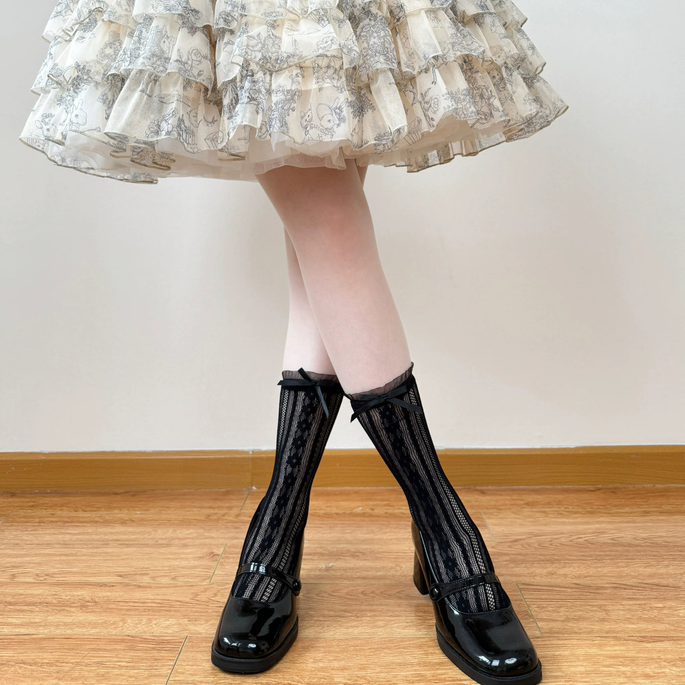White and black openwork lace mid-calf socks with scalloped bow cuffs.