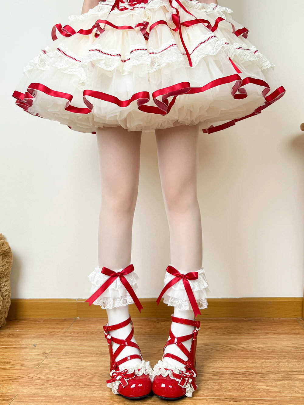 White mid-calf socks with lace cuffs and red bows styled with red shoes.