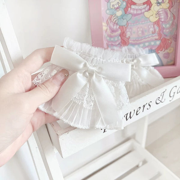 White lace sleeve cuffs with bows worn at the wrists.