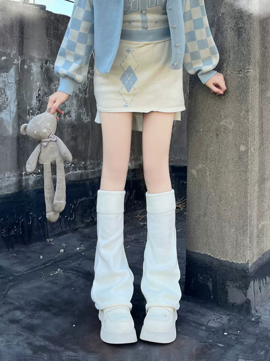 White knitted flared leg warmers with rolled edges styled over white platform shoes.