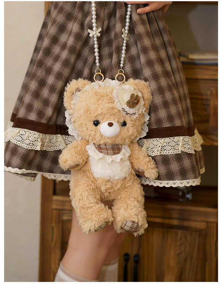 Tan plush bear crossbody bag with lace details and a beaded chain.