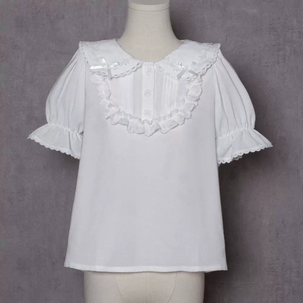 White short-sleeve blouse with lace-edged collar, bows and button front on mannequin