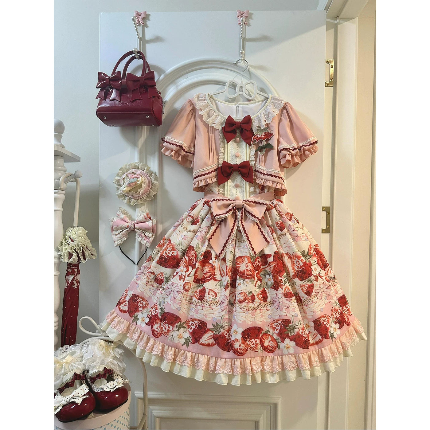 Pink-and-cream faux two-piece strawberry-print OP dress with burgundy bows and lace trim